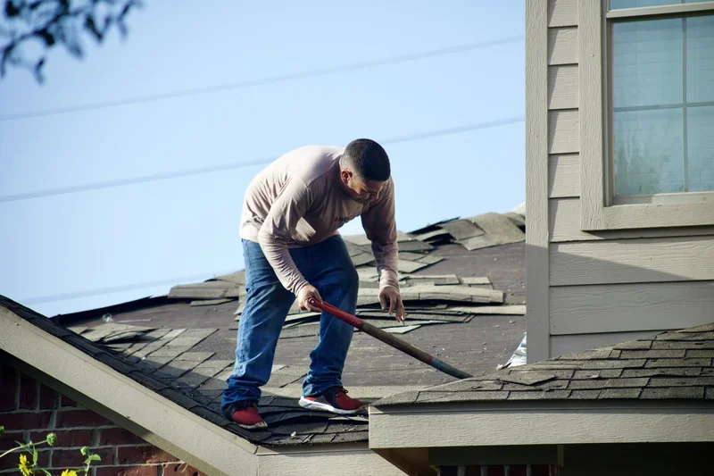 Roofer walking the edge of a shingle roof to check its condition